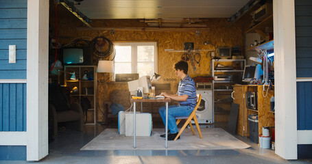 Leinwandbilder - Caucasian Male Software Engineer Programming On Old Desktop Computer In Retro Garage With Random Appliances. Man Working On Innovative Online Service Startup Company In Nineties. Nostalgia Concept.