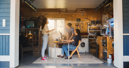 Fototapete - Diverse Team Of Three Young Tech Startup Company Founders Working In Retro Garage, Using Old Desktop Computer. Male And Female Entrepreneurs Developing Innovative Online Service In Nostalgic Nineties.