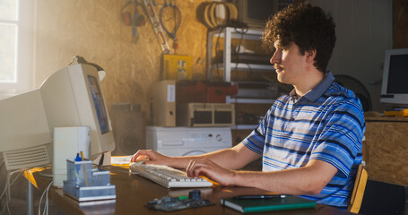 Leinwandbilder - Caucasian Male Software Engineer Programming On Old Desktop Computer In Retro Garage. Enthusiast Browsing Early Internet Forums, Coding Applications, Chatting Online In Nineties. Nostalgia Concept.