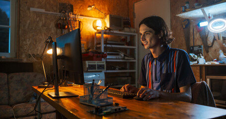 Fototapete - Caucasian Male Software Engineer Coding on Desktop Computer In Garage In The Evening. Man Starting Technological Startup Company. Coding Innovative Online Service At Home.