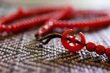 Wall Mural - Red tasbih ( muslim prayer beads ) with star and crescent. Symbol of Islam.