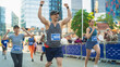 © Gorodenkoff - Portrait of Smiling Middle Aged Man Running in a City Marathon, Waving at the Supportive Audience. Friendly Happy Male Runner Celebrating Crossing the Finish Line in a Race
