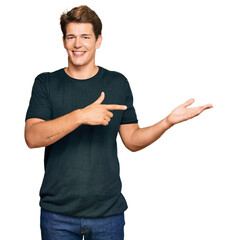 Wall Mural - Handsome caucasian man wearing casual clothes amazed and smiling to the camera while presenting with hand and pointing with finger.