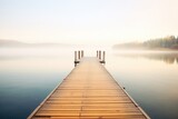 Fototapeta Pomosty - wood plank pier extending out over calm lake waters