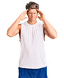 © Krakenimages.com - Young handsome man wearing sleveeless t shirt suffering from headache desperate and stressed because pain and migraine. hands on head.