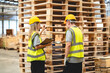 © chokniti - Professional Engineer, carpenter or worker team are checking and inspecting hardwood, timber or wooden pallet material for furniture production. Technician is wearing a hardhat while monitoring stock.