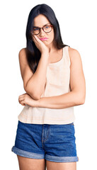 Sticker - Young beautiful caucasian woman wearing casual clothes and glasses thinking looking tired and bored with depression problems with crossed arms.