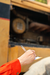 Wall Mural - action of an engineer hand is writing to perform inspection of the road roller or road compactor mac