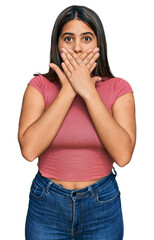 Wall Mural - Young hispanic girl wearing casual t shirt shocked covering mouth with hands for mistake. secret concept.