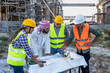 © Jack Tamrong - Construction builder men and woman workers explain project paperwork to Arab developer at construction site