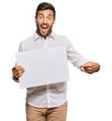 © Krakenimages.com - Handsome hispanic man holding blank empty banner smiling happy pointing with hand and finger