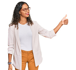 Canvas Print - Young african american girl wearing business clothes looking proud, smiling doing thumbs up gesture to the side