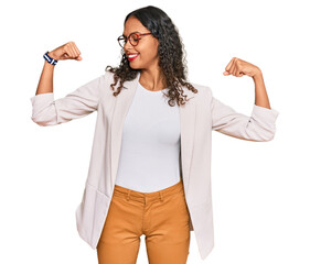 Wall Mural - Young african american girl wearing business clothes showing arms muscles smiling proud. fitness concept.