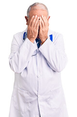 Wall Mural - Senior handsome grey-haired man wearing doctor coat and stethoscope with sad expression covering face with hands while crying. depression concept.