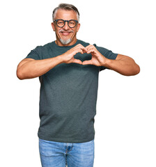 Sticker - Middle age grey-haired man wearing casual clothes and glasses smiling in love showing heart symbol and shape with hands. romantic concept.