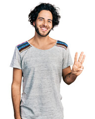 Canvas Print - Young hispanic man wearing casual t shirt showing and pointing up with fingers number three while smiling confident and happy.