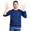 © Krakenimages.com - Young hispanic man wearing casual clothes showing and pointing up with fingers number ten while smiling confident and happy.