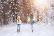 © alexkich - Young family for a walk. Mom and daughter are walking in a winter park.