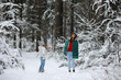 © alexkich - Young family for a walk. Mom and daughter are walking in a winter park.