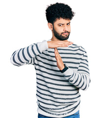 Poster - Young arab man with beard wearing casual striped sweater doing time out gesture with hands, frustrated and serious face