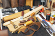 Tools and leather at cobbler workplace. Set of leather craft tools on wooden background.