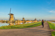 © Noppasinw - Dutch Windmill landscape at Kinderdijk Village Netherlands with woman tourist