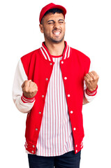 Poster - Young hispanic man wearing baseball uniform excited for success with arms raised and eyes closed celebrating victory smiling. winner concept.