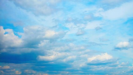 Wall Mural - White, cumulus clouds move and transform. Above them, in a separate layer, the clouds move in the other direction.