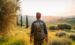 Male hiker traveling, walking alone Italian Tuscan Landscape view under sunset light. Man traveler enjoys with backpack hiking in mountains. Travel, adventure, relax, recharge concept.	
