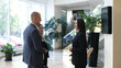 © Vladislav - Business woman assistant director meets investors. Business people meeting in the lobby of a modern corporate office for a business meeting.