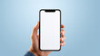 Hand holding a smartphone with a blank white screen against a blue background, offering a clear display for a mockup or app presentation.