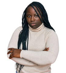 Wall Mural - Young black woman with braids wearing casual winter sweater skeptic and nervous, disapproving expression on face with crossed arms. negative person.