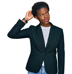 Wall Mural - Young african american girl wearing business clothes confuse and wondering about question. uncertain with doubt, thinking with hand on head. pensive concept.