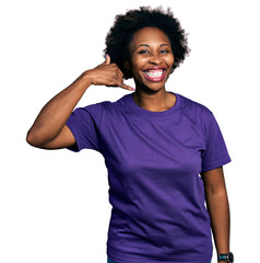 Canvas Print - African american woman with afro hair wearing casual purple t shirt smiling doing phone gesture with hand and fingers like talking on the telephone. communicating concepts.