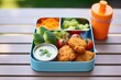 nuggets in a lunchbox with vegetables