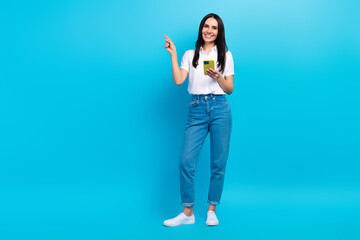 Poster - Full length photo of dreamy pretty lady wear white shirt typing modern device pointing empty space isolated blue color background