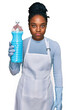 © Krakenimages.com - Young african american woman wearing apron holding detergent bottle thinking attitude and sober expression looking self confident