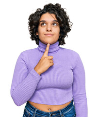 Canvas Print - Young hispanic woman with curly hair wearing casual clothes thinking concentrated about doubt with finger on chin and looking up wondering