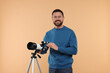 Smiling astronomer with telescope on beige background
