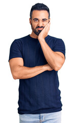 Wall Mural - Young hispanic man wearing casual clothes thinking looking tired and bored with depression problems with crossed arms.