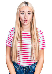 Poster - Beautiful blonde woman wearing casual striped t shirt making fish face with lips, crazy and comical gesture. funny expression.