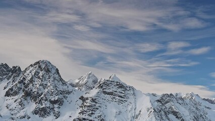 Wall Mural - Alpine peaks with moving clouds in the sky