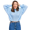 © Krakenimages.com - Young brunette woman wearing casual winter sweater crazy and scared with hands on head, afraid and surprised of shock with open mouth