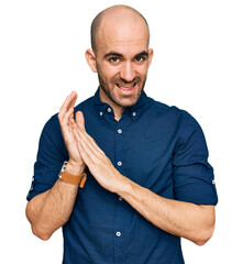 Wall Mural - Young hispanic man wearing casual clothes clapping and applauding happy and joyful, smiling proud hands together