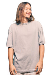 Sticker - Handsome caucasian man with long hair wearing casual clothes looking away to side with smile on face, natural expression. laughing confident.