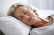 Middle-aged woman sleeping on white pillow