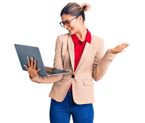 Sticker - Young beautiful woman holding laptop celebrating victory with happy smile and winner expression with raised hands