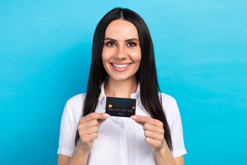 Sticker - Photo of charming shiny lady wear white shirt holding credit card smiling isolated blue color background