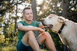 © Chalabala - Portrait of man with cute dog sitting in grass under tree. Happy owner of labrador retriever resting in nature on sunny summer day..