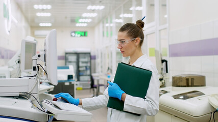 A female scientist controls the operation of devices for laboratory research. Modern laboratory technologies. Medical research centrifuge.